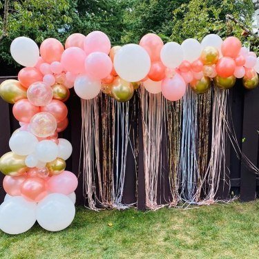 Balloon Garland-Over-Backyard-Fence-With-Foil-Shimmer-Backdrop